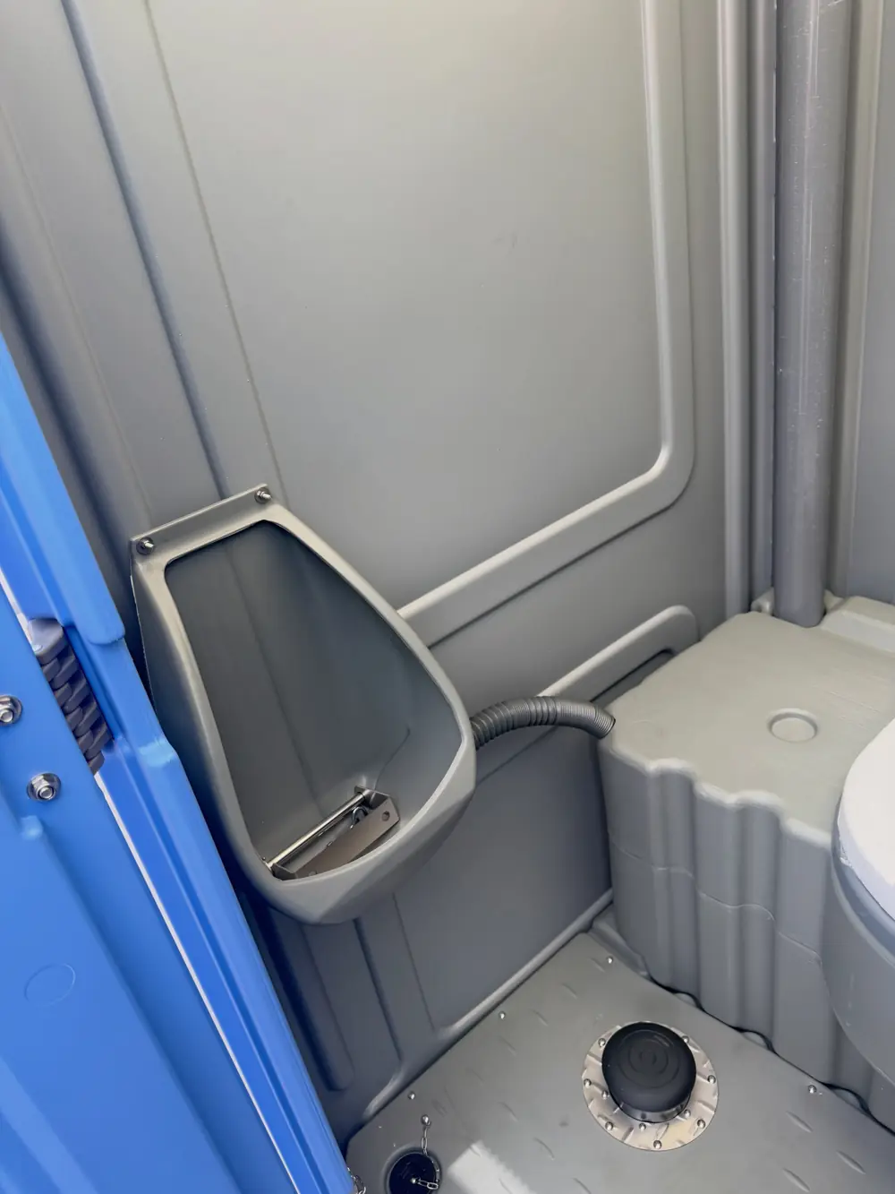 Urinal inside a gray standard porta potty